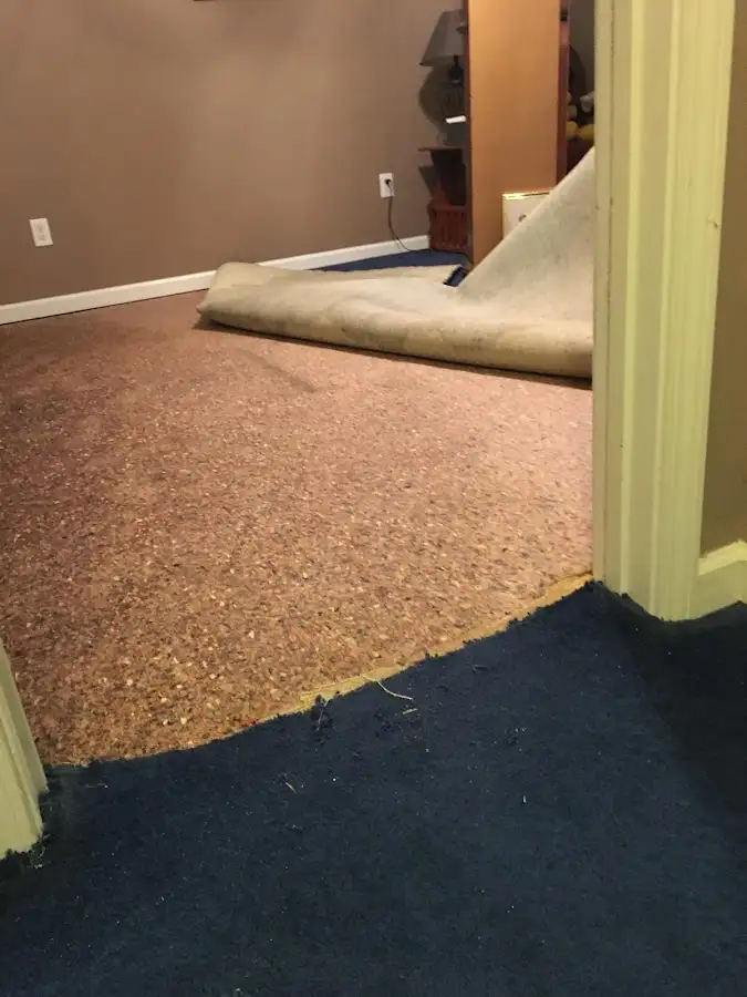 Carpet pad removal revealing water damage during Water Mitigation Services in Pensacola